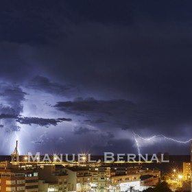 Photograph of a stormy night in Alicante with numerous lightning and lots of rain. Space for text.