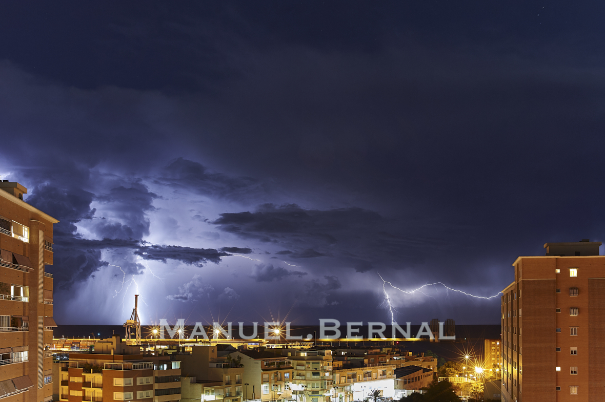 Photograph of a stormy night in Alicante with numerous lightning and lots of rain. Space for text.